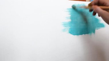 Düz fırçalar ile tuval üzerinde mavi yağlı boya ile beyaz bir tuval üzerine resim olan sanatçı boyalar çeşitli vuruş uygulanan. Yakın çekim çekim 