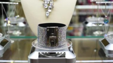 Takı, kolye, yüzük, küpe, bilezik, lambalar düşen ışıkta mağaza penceresi pırıltılı ışınları üzerinde kolyeler 