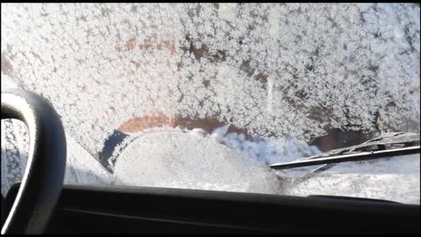 挡风玻璃雨刷清洁汽车的挡风玻璃 防止冰冻的雪和冰晶 水从底部向上倒在挡风玻璃上 有助于融化冰 在上午 — 图库视频影像