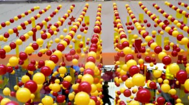Dekorasyon ve dekorasyon için kırmızı ve sarı parlak boncuklar alışveriş merkezinde yatay olarak gergin ipleri asmak. Eğlenceli bir festival ruh yaratmak hava akışı sallanan  