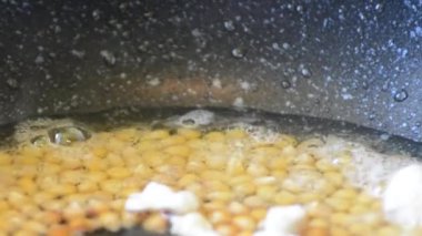 Popcorn sıcak kaynatma bitkisel yağ haşlanmış, patlar ve kızarmış Mısır kokulu kokusu yayan, açıldığında vuruyor