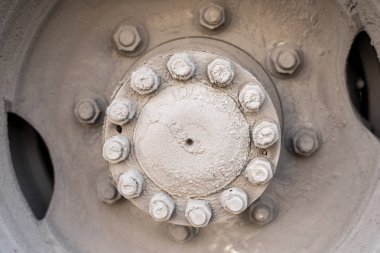 Otobüsün arka tekerleğinin hub 'ı veya cıvata ve fındık ile büyük bir makine, yol çamur kum ve tuz karışımı ile kaplı otobüs çarkı hub 'ın gün ışığında taşıyan kirli tekerlek