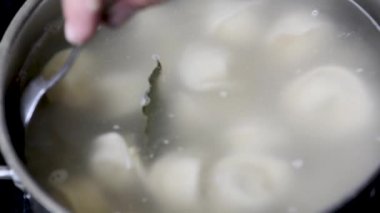 Mantı baharatlarla suda kaynar kaynar kaynar kaynar bir tavada köftekapatın. Ev pişirme Kaynar suda pişirme köfte veya ravioli yavaş yavaş kaynama onları koyarak  