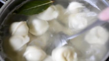 Mantı baharatlarla suda kaynar kaynar kaynar kaynar bir tavada köftekapatın. Ev pişirme Kaynar suda pişirme köfte veya ravioli yavaş yavaş kaynama onları koyarak  
