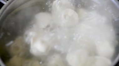 Mantı baharatlarla suda kaynar kaynar kaynar kaynar bir tavada köftekapatın. Ev pişirme Kaynar suda pişirme köfte veya ravioli yavaş yavaş kaynama onları koyarak  
