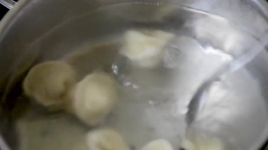Mantı baharatlarla suda kaynar kaynar kaynar kaynar bir tavada köftekapatın. Ev pişirme Kaynar suda pişirme köfte veya ravioli yavaş yavaş kaynama onları koyarak  
