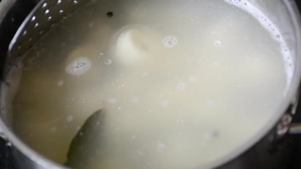 ラビオリは 沸騰した水の鍋の上にスキマーに餃子のクローズアップスパイスで水で沸騰 家庭料理餃子やラビオリを沸騰水に徐々に沸騰させる — ストック動画