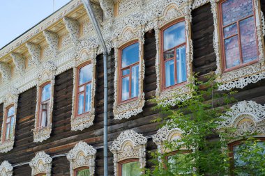18. yüzyılın ortalarında eski ev, eski harap boya ile binanın ön ve çatı pencere ve çatı ahşap oyma elemanları Mavi gökyüzüne karşı gün ışığında evin üzerinde oyma Antik ahşap