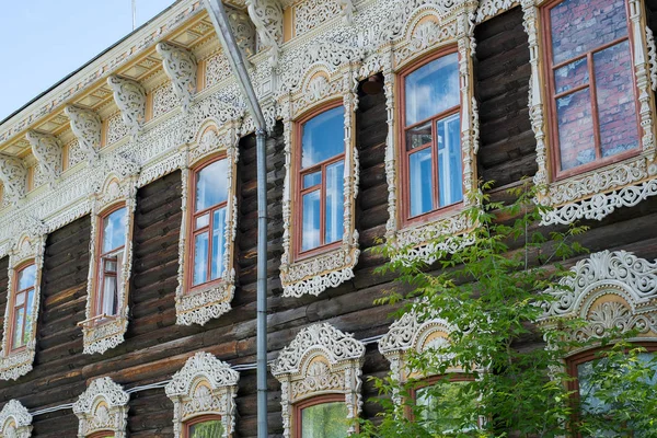 18. yüzyılın ortalarında eski ev, eski harap boya ile binanın ön ve çatı pencere ve çatı ahşap oyma elemanları Mavi gökyüzüne karşı gün ışığında evin üzerinde oyma Antik ahşap