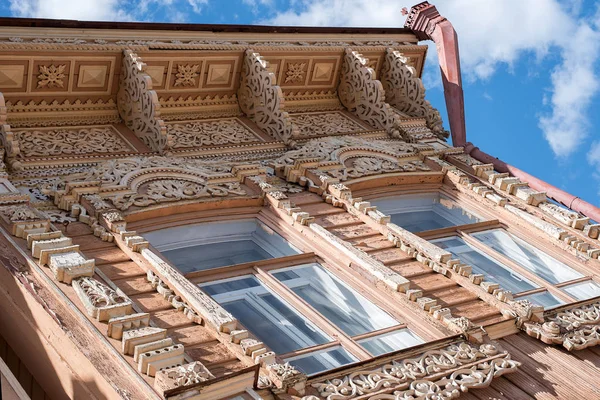 18. yüzyılın ortalarında eski ev, eski harap boya ile binanın ön ve çatı pencere ve çatı ahşap oyma elemanları Mavi gökyüzüne karşı gün ışığında evin üzerinde oyma Antik ahşap