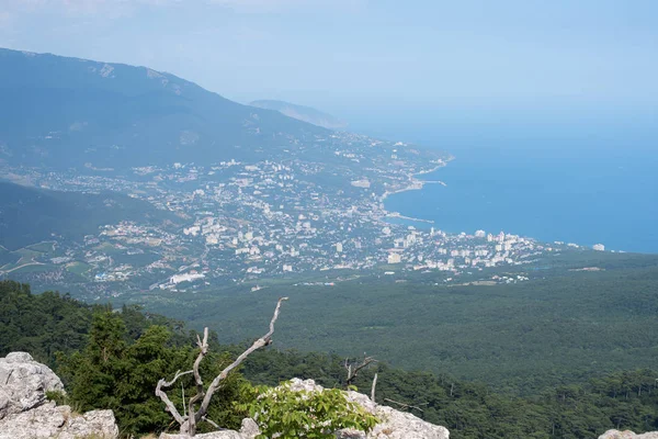 The sea and the city from the mountains from the bird\'s eye view of the beautiful blue sea of water reflecting the clouds on the background of green mountains and South of the city Sea city on the background of greenery and the sea in the afternoon