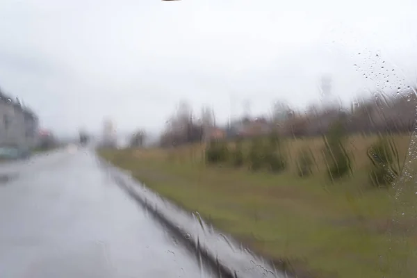 Arka planlar ve dokular ön camdan görünümü, yağmur ile sular altında, cam ve bulanık nesneler üzerinde damla ile renkli evler ve sokakları dışında yağmurlu havalarda Araba ön cam 