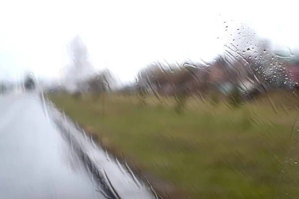 Arka planlar ve dokular ön camdan görünümü, yağmur ile sular altında, cam ve bulanık nesneler üzerinde damla ile renkli evler ve sokakları dışında yağmurlu havalarda Araba ön cam 