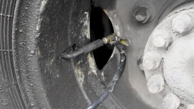 Yağmurlu havalarda siyah hortumlu şişme lastik kompresör ve dış basınç sensörü Pompa, yağmurda kirli tekerleği doğal ışıkta şişirir