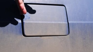 Eski retro araba mavisi üzerindeki gaz tankının kapağının açılması Yarıştan sonra kirle kaplı retro bir arabada gaz tankı kapağı açılır 