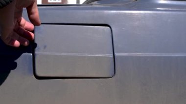 Eski retro araba mavisi üzerindeki gaz tankının kapağının açılması Yarıştan sonra kirle kaplı retro bir arabada gaz tankı kapağı açılır 