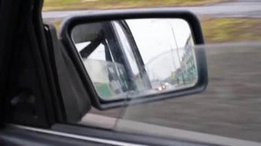 Bir retro araba, bir ev yolu ve bir araba daldırma farlar ile arkasında sürüş kirli ayna ile görünümü. sovefory ve yol işaretleri Sağ kirli araba dikiz aynası, ayna görünümü 