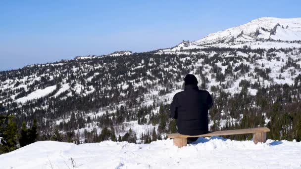 Een Man Rookt Zittend Een Bankje Een Skigebied Bewondert Het — Stockvideo