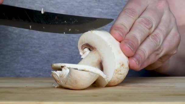 여성이 부엌에서 손잡이가 버섯을 자른다 절단의 클로즈업 요리를위한 보드에 버섯을 — 비디오
