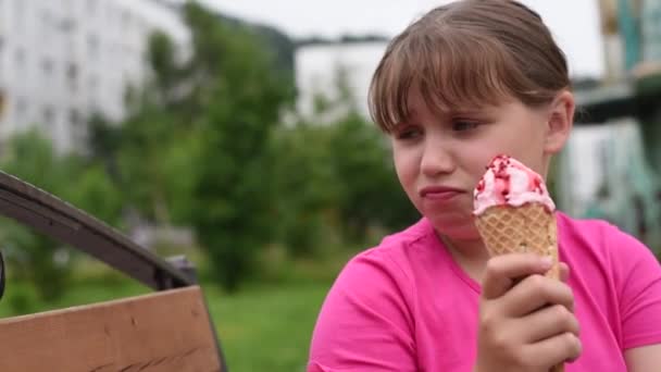 女孩想吃冰淇淋 女孩从草莓冰淇淋中取出包装纸 — 图库视频影像