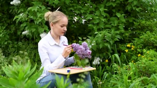 若い女の子 創造性に従事するアーティスト 庭で生きたライラックを描く — ストック動画