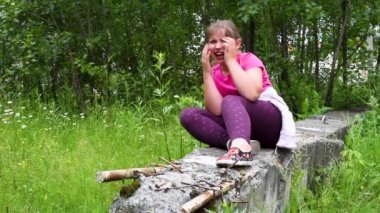 Girlie patlama tarafından tahrip evin kalıntıları üzerinde oturur ve kız onun harap evinde yaz aylarında eve döndü ağlıyor  