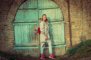 Kedi bir leash üzerinde. Bir kız omuzunda oturur bir kedi ile yürüyor