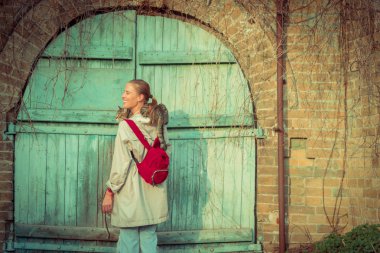 Kedi bir leash üzerinde. Bir kız omuzunda oturur bir kedi ile yürüyor