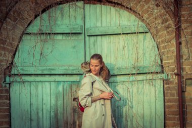 Kedi bir leash üzerinde. Bir kız omuzunda oturur bir kedi ile yürüyor