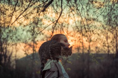Kedi bir leash üzerinde. Bir kız omuzunda oturur bir kedi ile yürüyor