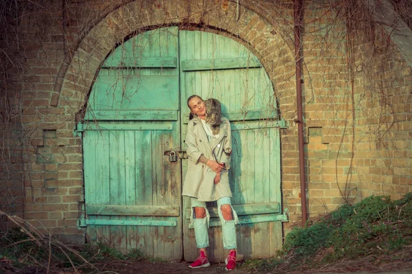 Kedi bir leash üzerinde. Bir kız omuzunda oturur bir kedi ile yürüyor