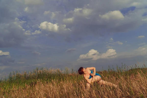 Yoga. Girl in a field in nature practicing yoga