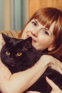 Kara kedi. Siyah bir kedi kız hugs