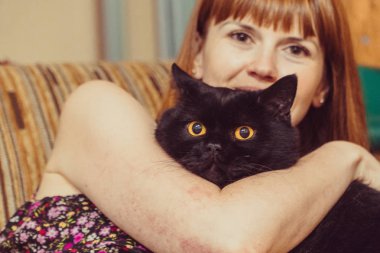 Kara kedi. Siyah bir kedi kız hugs