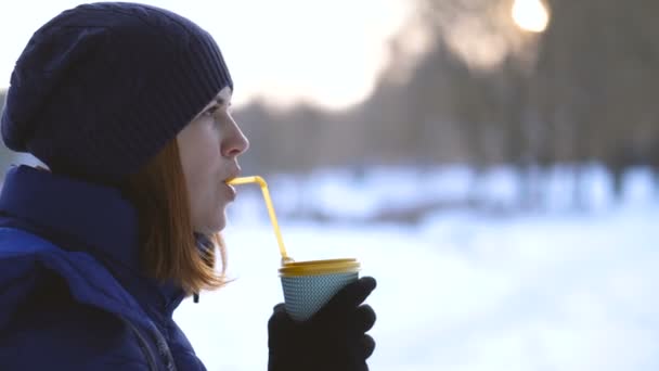 コーヒー 女の子の冬の公園でコーヒーを飲みながら — ストック動画