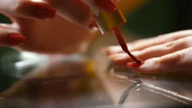 El tırnakları kırmızı cila ile boyar. Video 25 kare