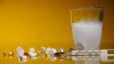 Tıbbi hapları bir termometre ve bir bardak su ile. 4 k video 25 kare