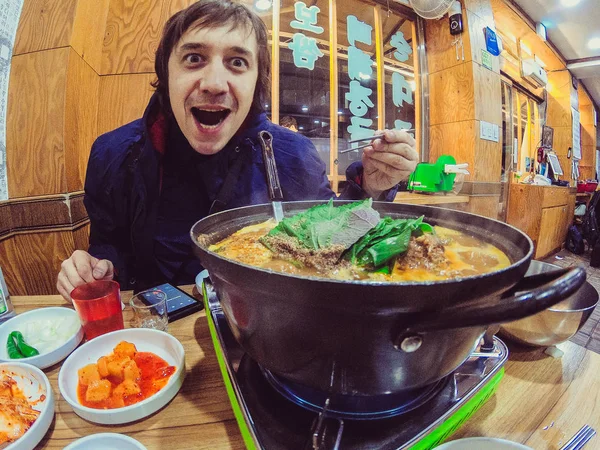 Guy tries Korean food in Seoul — Stock Photo, Image