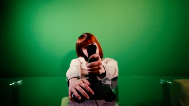 女の子はジョイスティックでコンピュータゲームをします 緑の背景 — ストック動画