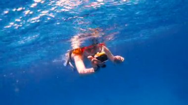 Bir aksiyon kamerası ile Şnorkel Kız denizde yüzer ve bir video kamera çeker
