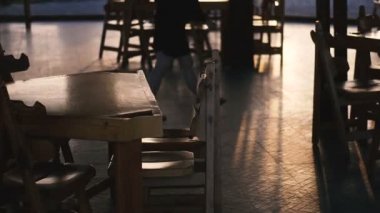 Bar. Tables illuminating the sunset in the background is the silhouette of a man