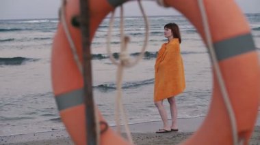 Lifebuoy. Sıcak bir havlu bir kız deniz kenarında duruyor