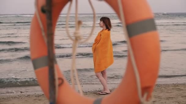 Lifebuoy Ένα Κορίτσι Μια Ζεστή Πετσέτα Στέκεται Κοντά Στη Θάλασσα — Αρχείο Βίντεο