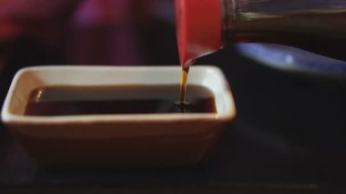 Soya sosu. Soya sosu bir kap içine dökülür