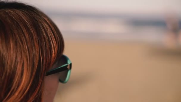 Uma Menina Óculos Sol Está Olhando Para Mar Silhuetas Pessoas — Vídeo de Stock