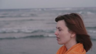 Havlu. Havluya sarılmış kız deniz kenarında duruyor