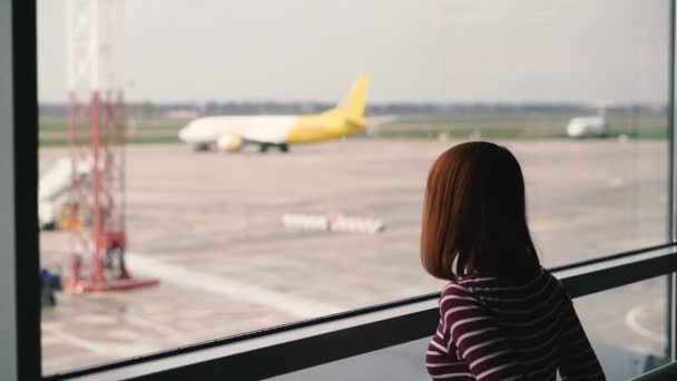 Flughafen Das Mädchen Blickt Aus Dem Fenster Auf Das Flugzeug — Stockvideo