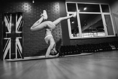 Başının üstünde dur. Kız spor salonunda egzersizler yapar