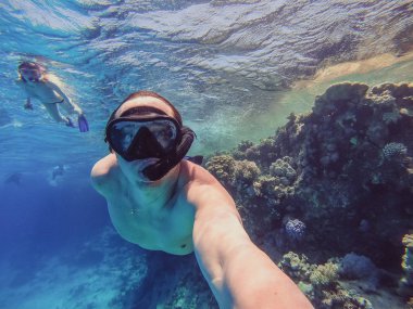 Şnorkel adam ve kız bir boru ve bir maske ile yüzmek