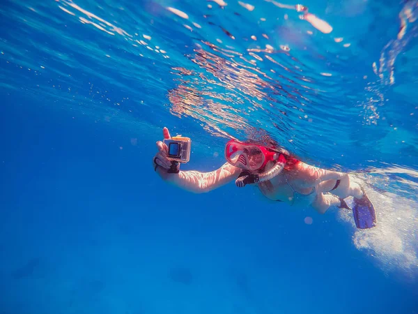 浮潜女孩与动作相机漂浮在大海和嘘 — 图库照片
